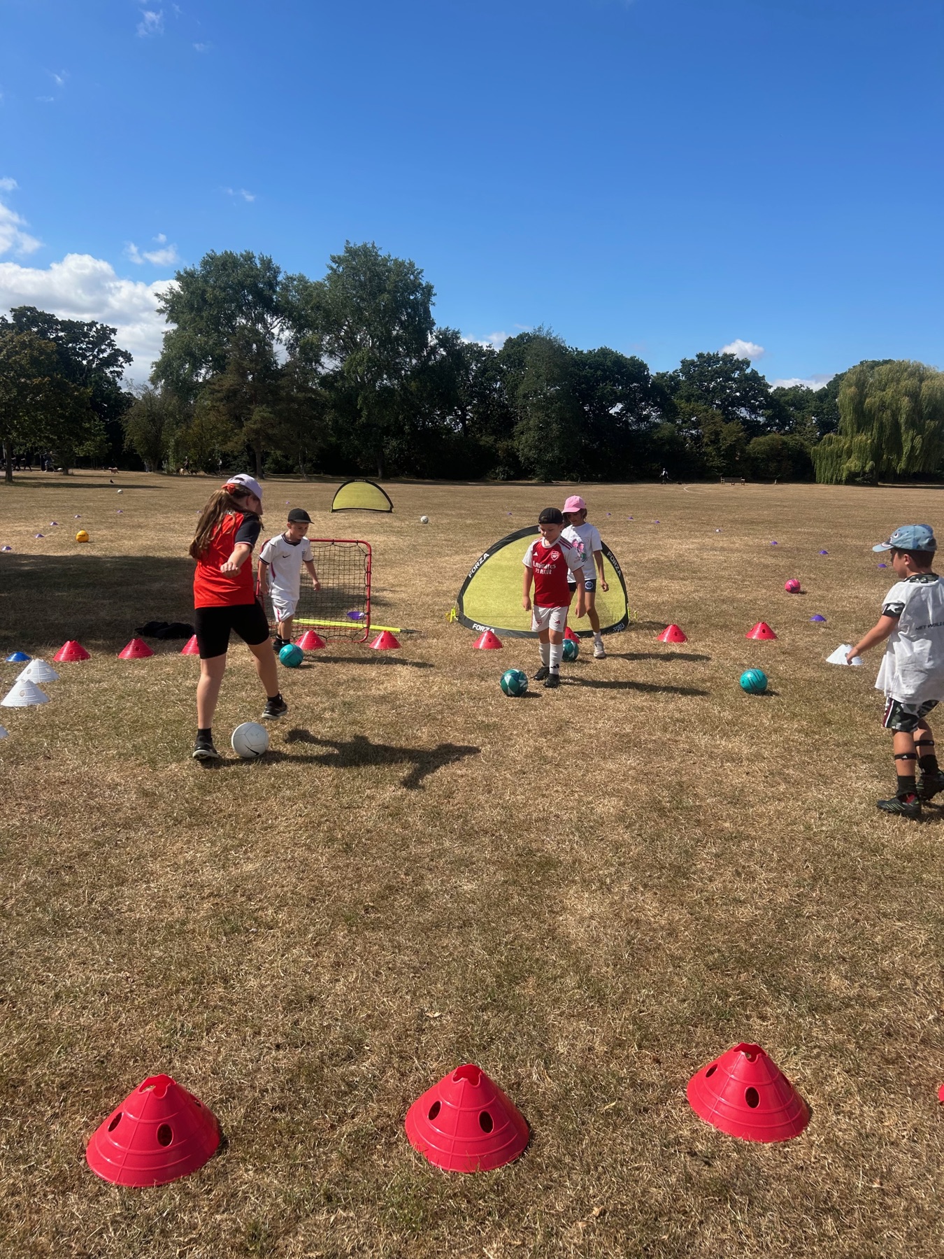 Children practising with footballs at an outdoor Football Frenzy session