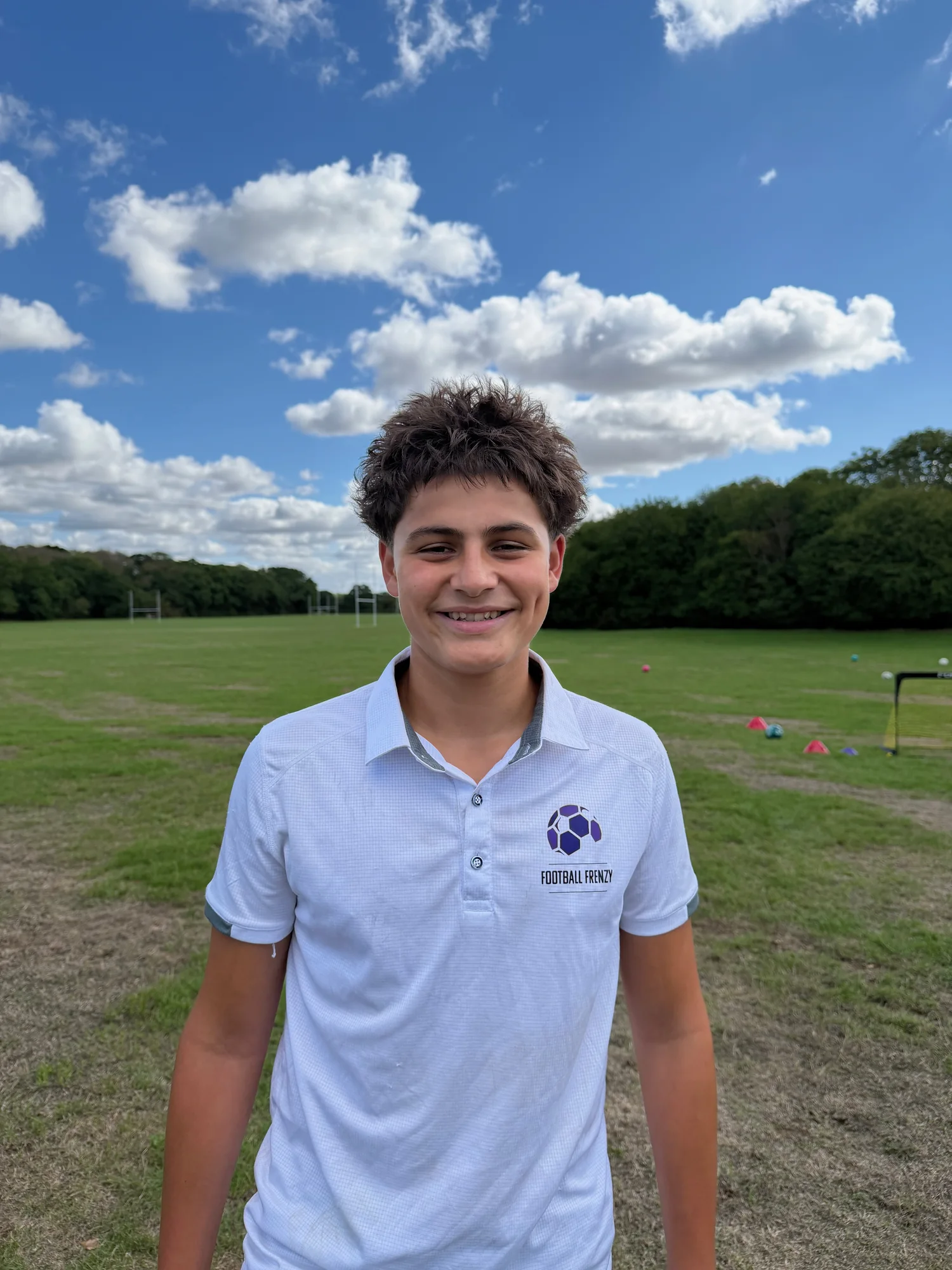 Coach Jesse smiling in his white Football Frenzy polo shirt